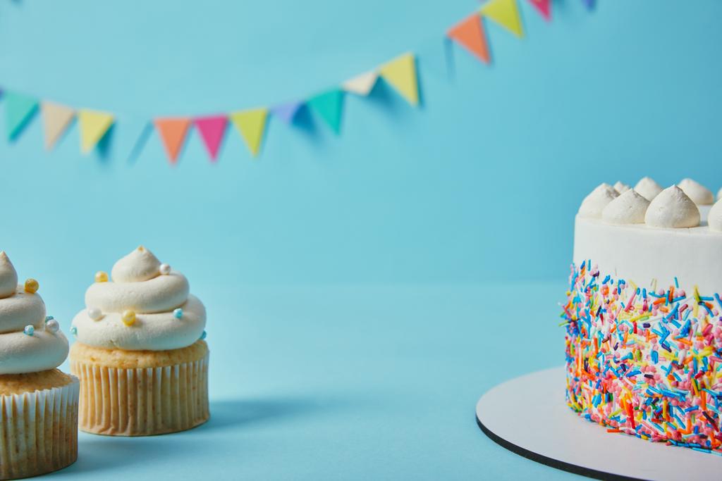 Вкусные кексы и торт на голубом фоне с овсянкой
 - Фото, изображение