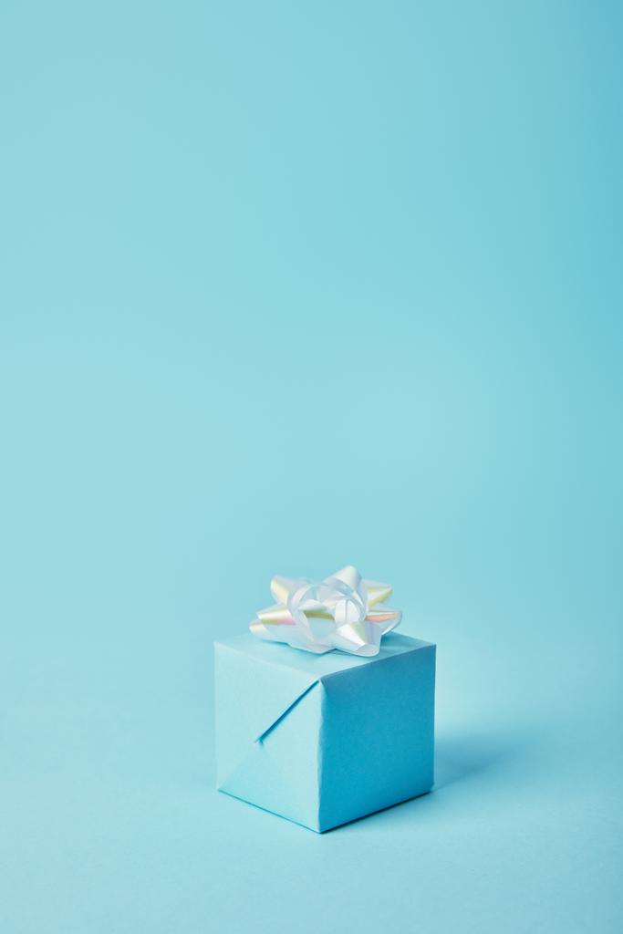 Lahjapakkaus valkoinen keula sinisellä taustalla
 - Valokuva, kuva