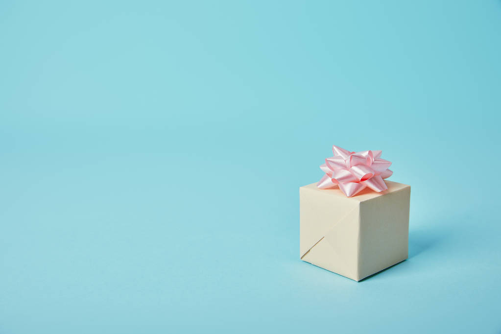 Gift box with pink bow on blue background - Photo, Image