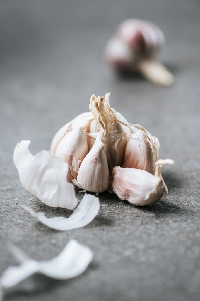 bulbo d'aglio sbucciato con buccia su tavolo di marmo grigio
 - Foto, immagini