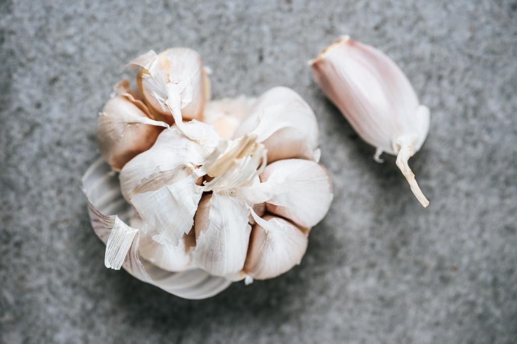 top view of peeled ripe garlic bulb on grey background - Photo, Image