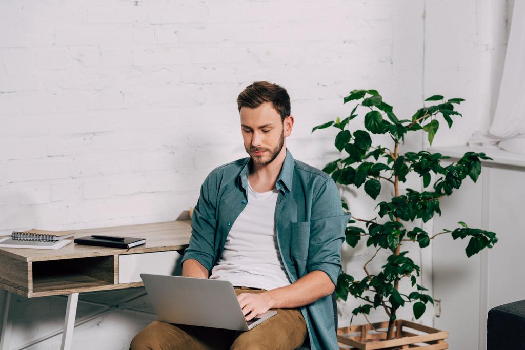 fiatal jóképű férfi szabadúszóként dolgozik laptop otthon - Fotó, kép
