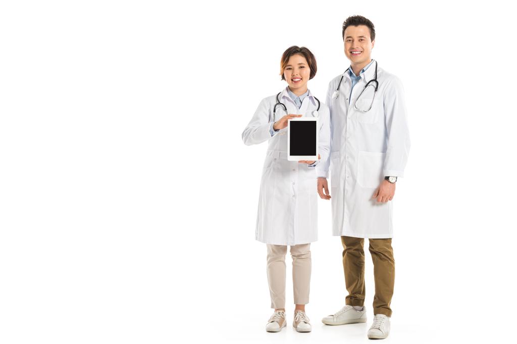 médicos femeninos y masculinos que presentan tableta digital con pantalla en blanco aislada en blanco
 - Foto, Imagen