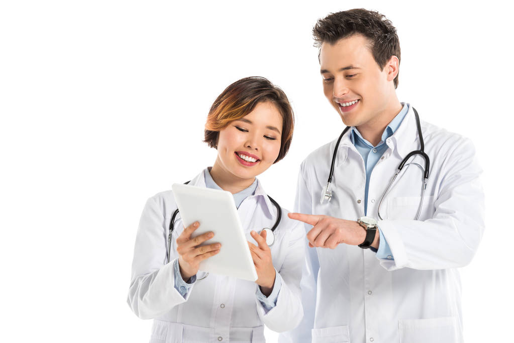 smiling female and male doctors with stethoscopes using digital tablet isolated on white - Photo, Image