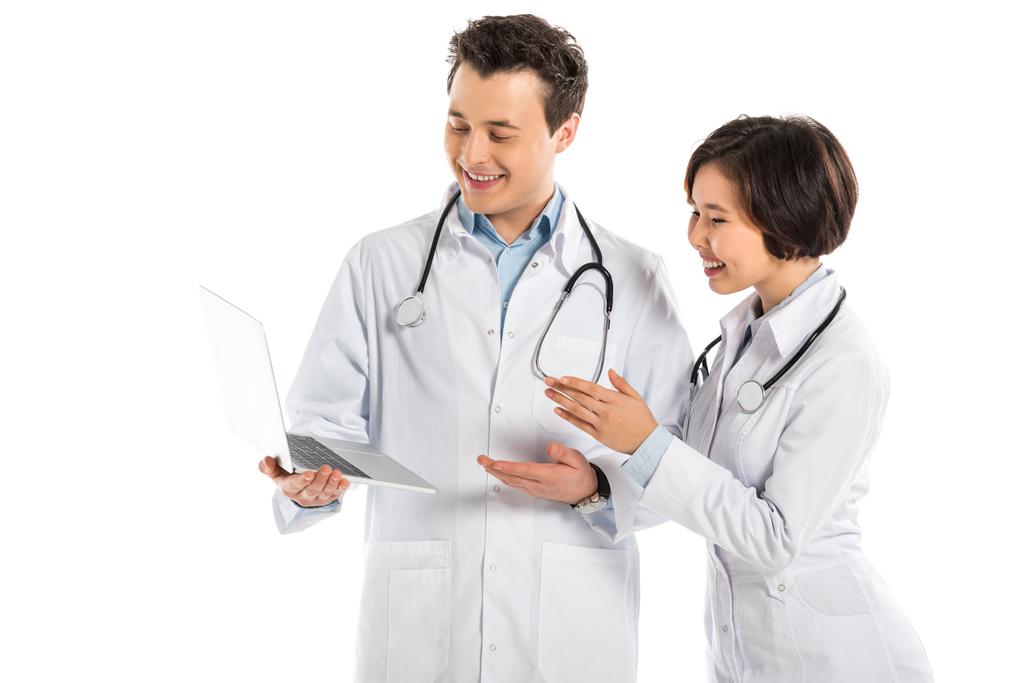 felizes médicos do sexo feminino e masculino usando laptop isolado no branco
 - Foto, Imagem