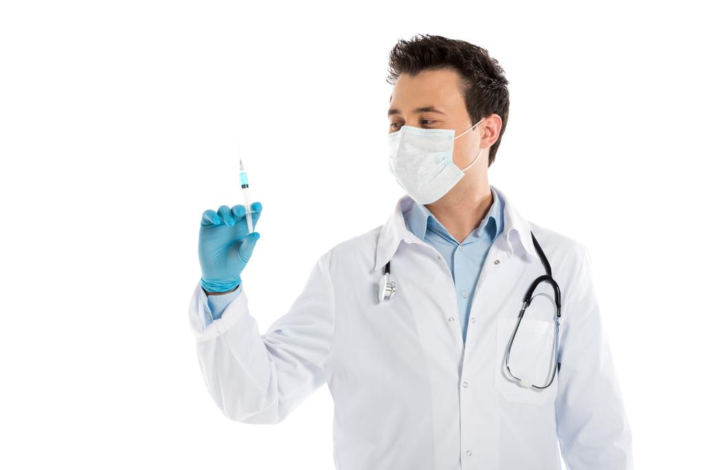 guapo doctor masculino en guantes de goma y mascarilla que sostiene la jeringa aislada en blanco
 - Foto, Imagen