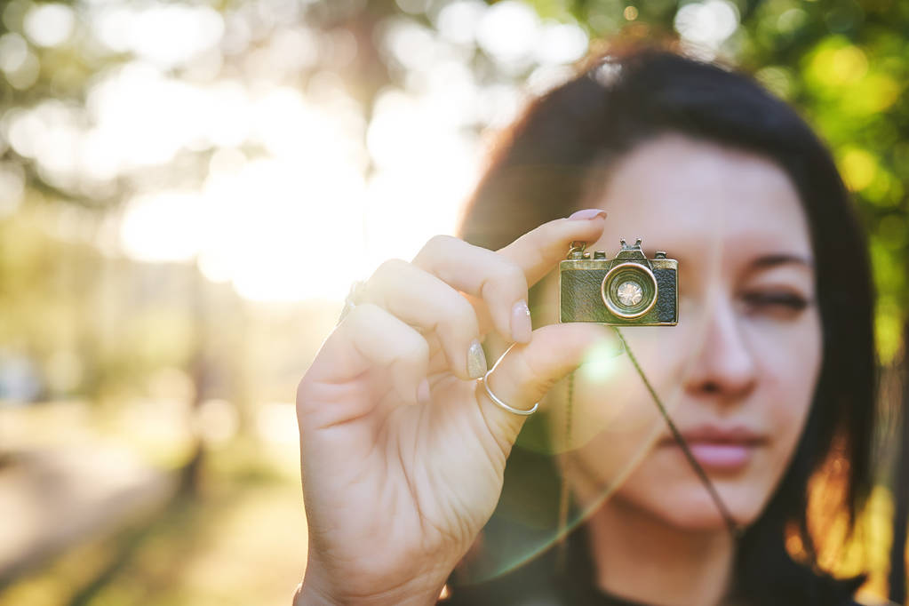 Vrouw-fotograaf, nemen van foto's op de camera van haar sieraden bij zonsondergang - Foto, afbeelding