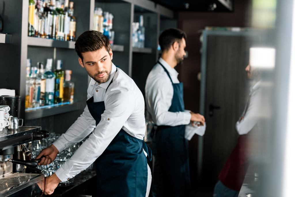 adulte beau barista dans tablier en utilisant une machine à café sur le lieu de travail
 - Photo, image