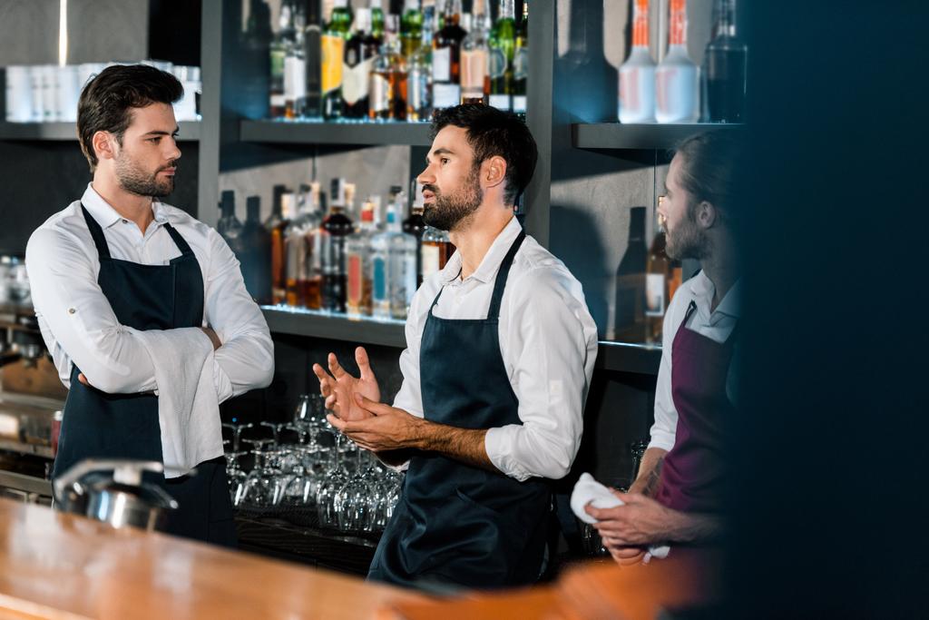 barman in grembiuli in piedi e comunicare sul posto di lavoro
  - Foto, immagini