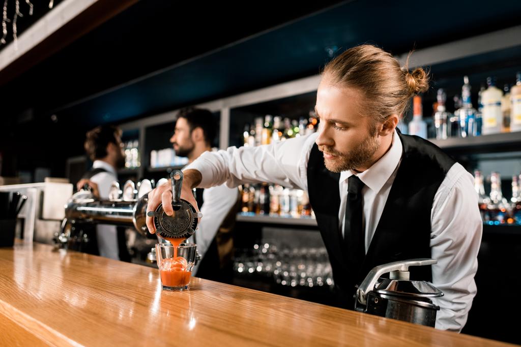 Бармен розливу коктейль в скло на барна стійка - Фото, зображення