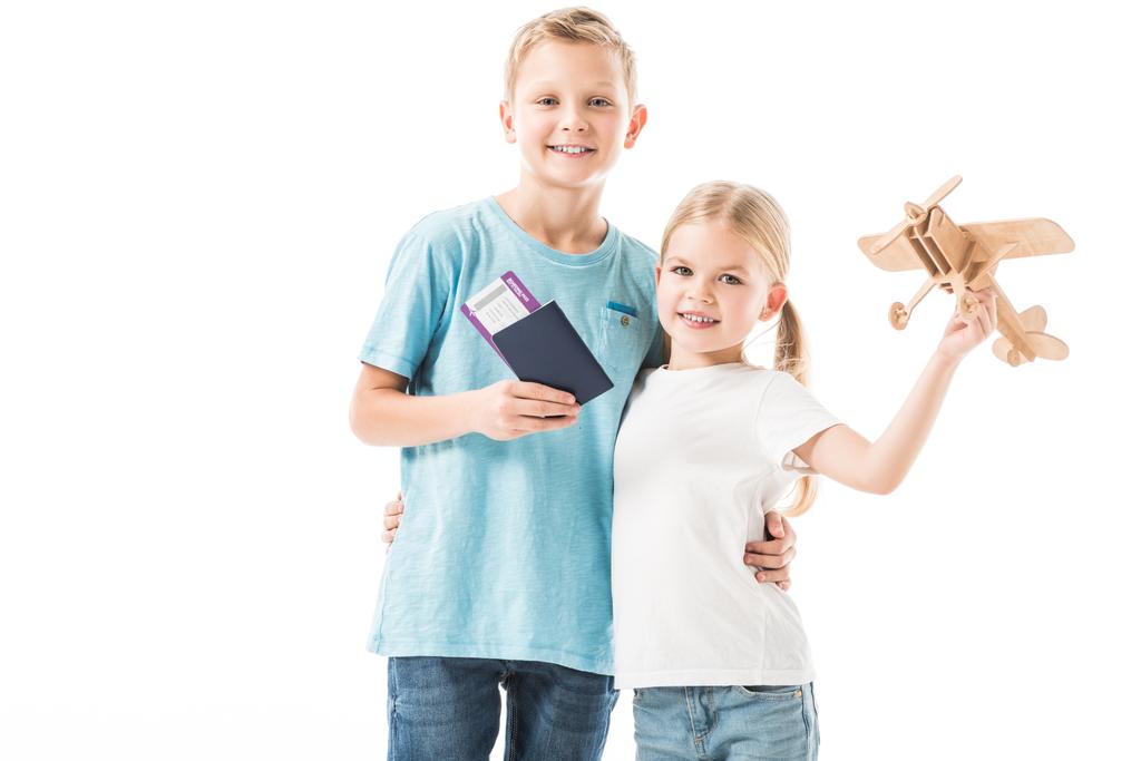 Dzieci stojąc z model samolotu, paszport i bilety na białym tle - Zdjęcie, obraz