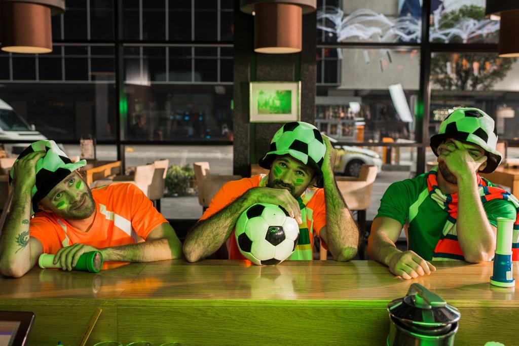 Topu ile oturma ve arkadaşlarınızla oyun izlerken futbol fan - Fotoğraf, Görsel