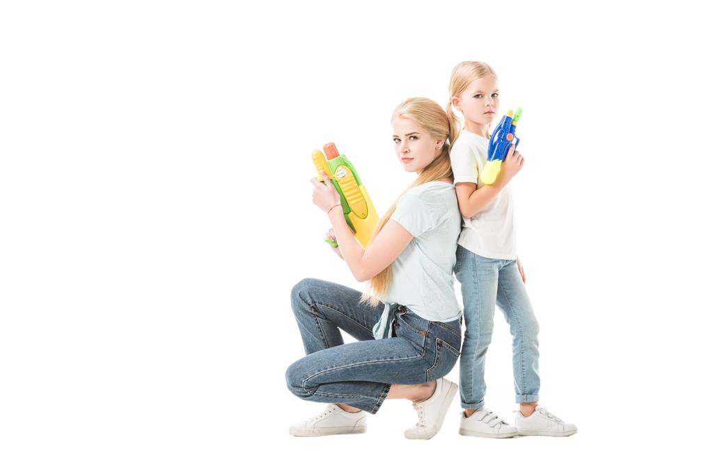 Mamá y su hija jugando con pistolas de agua aisladas en blanco
 - Foto, imagen