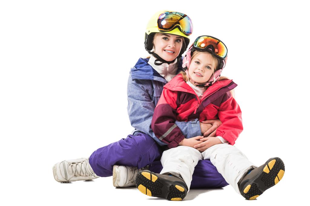 Pretty woman embracing preschooler daughter in ski suit and looking at camera isolated on white - Photo, Image