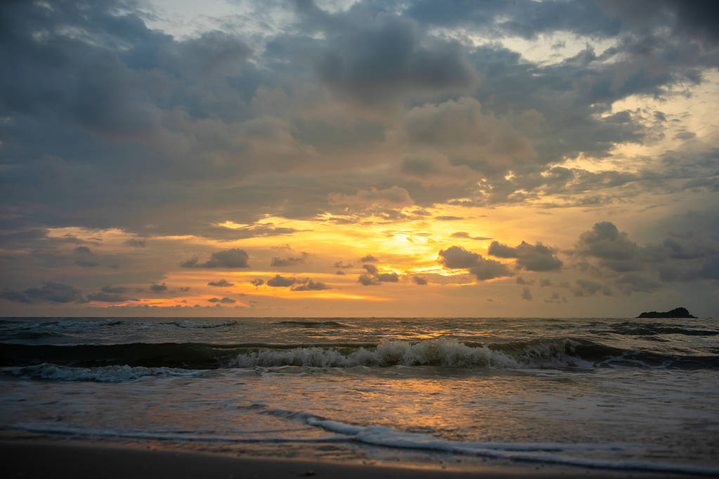 Céu nebuloso dourado ao pôr do sol na praia tropical calma e limpa
. - Foto, Imagem