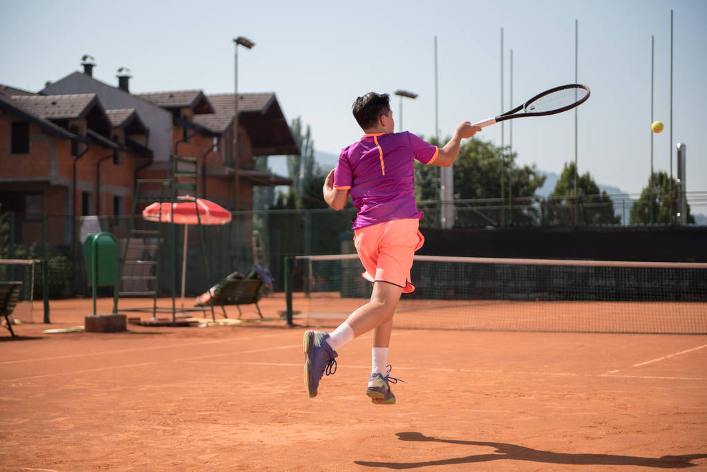 Jugador de tenis joven jugando de antemano
 - Foto, Imagen