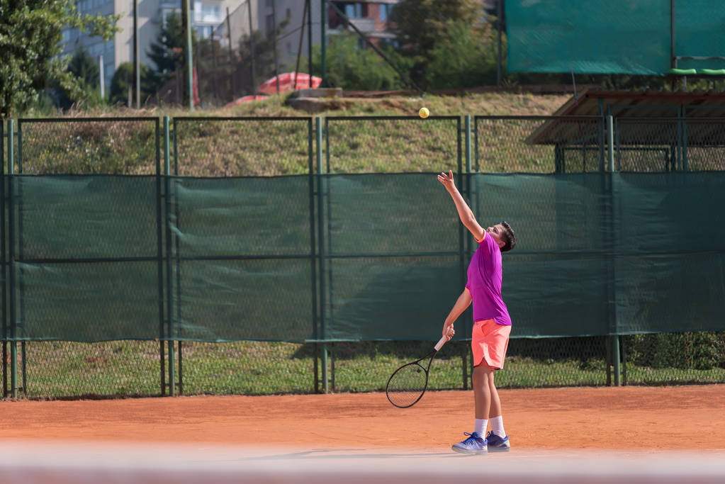 Молодой теннисист подает мяч
 - Фото, изображение
