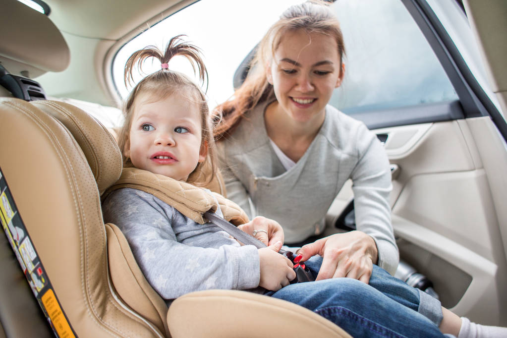 Bébé dans un siège auto pour enfant. transport sûr des enfants. voyages en famille. Maman questionne son enfant sur le siège auto
 - Photo, image