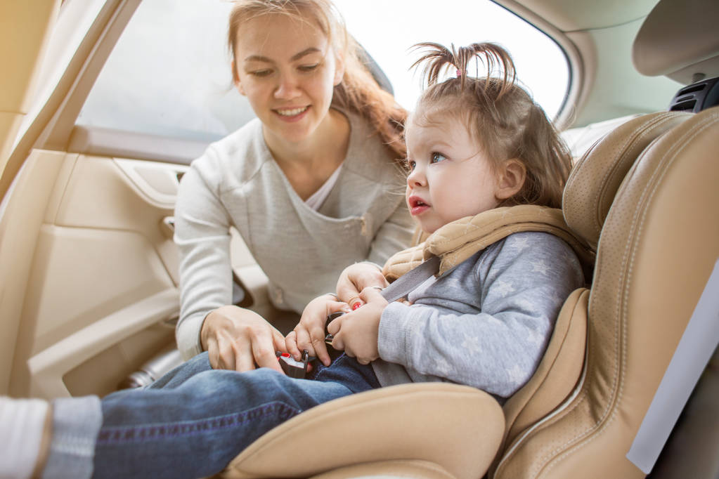 Bébé dans un siège auto pour enfant. transport sûr des enfants. voyages en famille. Maman questionne son enfant sur le siège auto
 - Photo, image
