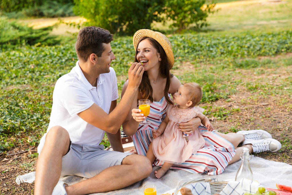 Wesoły młodych rodzin z małym dzieckiem dziewczyna spędzać czas razem w parku, piknik - Zdjęcie, obraz