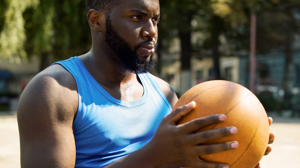 Topu tutan atletik Afro-Amerikan basketbol oyuncusu oyun için hazırlanıyor - Fotoğraf, Görsel