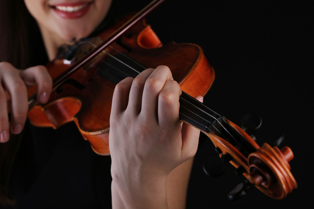 Музикант грає на скрипці на чорному тлі
 - Фото, зображення