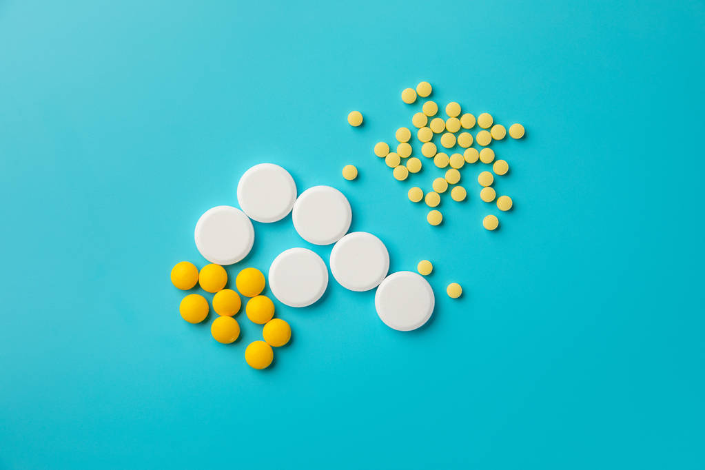 fehér és sárga gyógyszerek és a tabletták, a kék háttér. a szöveg másol hely. - Fotó, kép