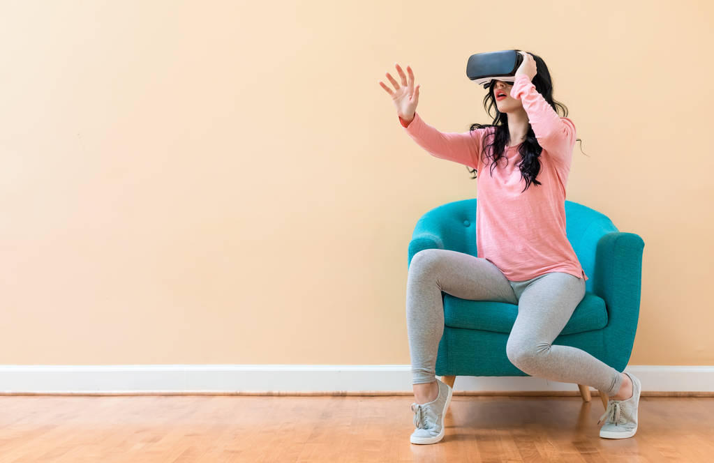молода жінка використовує гарнітуру віртуальної реальності
 - Фото, зображення