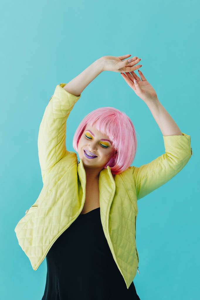 Mooie jonge vrouw met roze haren op blauwe achtergrond - Foto, afbeelding