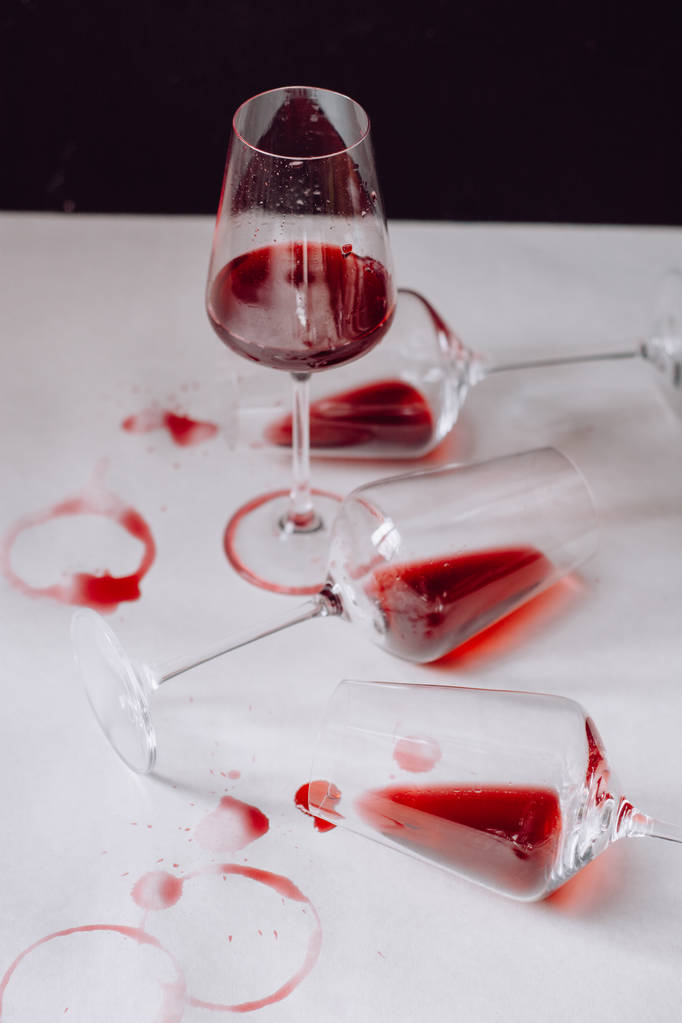 Vasos de vino tinto derramado sobre fondo blanco y oscuro, espacio para copiar. Concepto de degustación del vino
 - Foto, Imagen