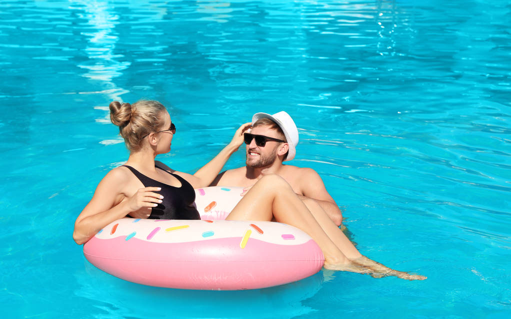 Щаслива молода пара з надувним кільцем у басейні
 - Фото, зображення
