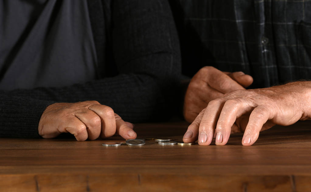 Szegény idős házaspár számlálás érmék az asztalnál, a hangsúly a kezek - Fotó, kép