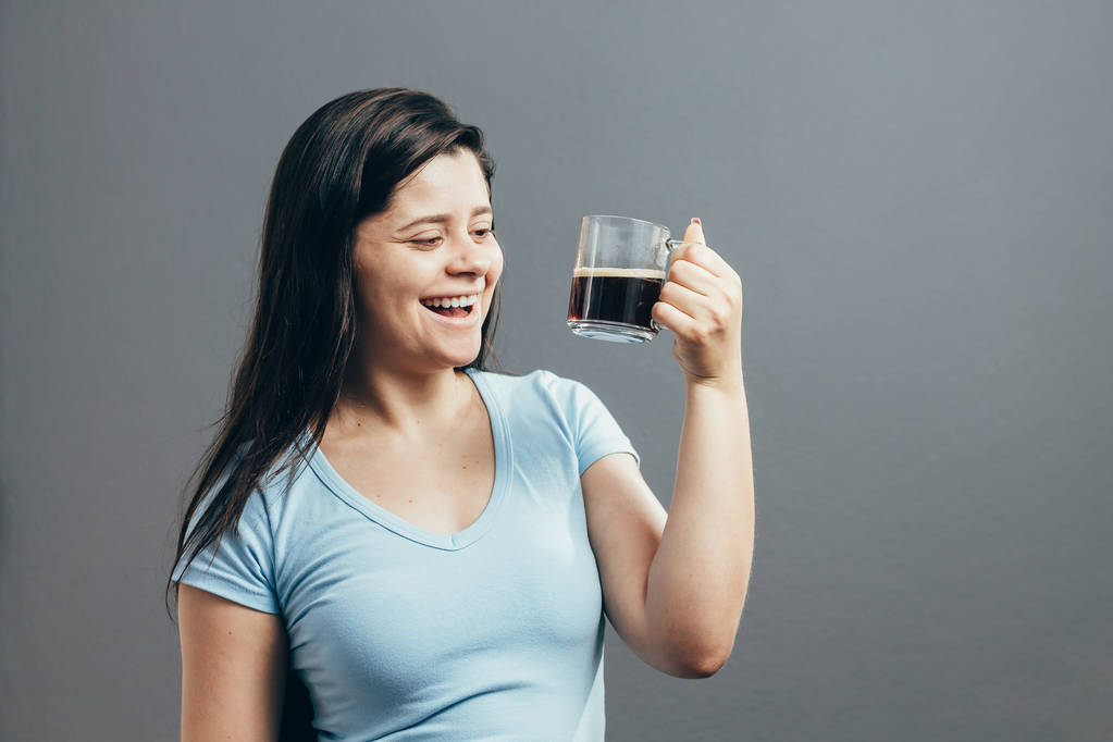 Gri arka plan üzerinde kahve içme genç kadın portresi - Fotoğraf, Görsel