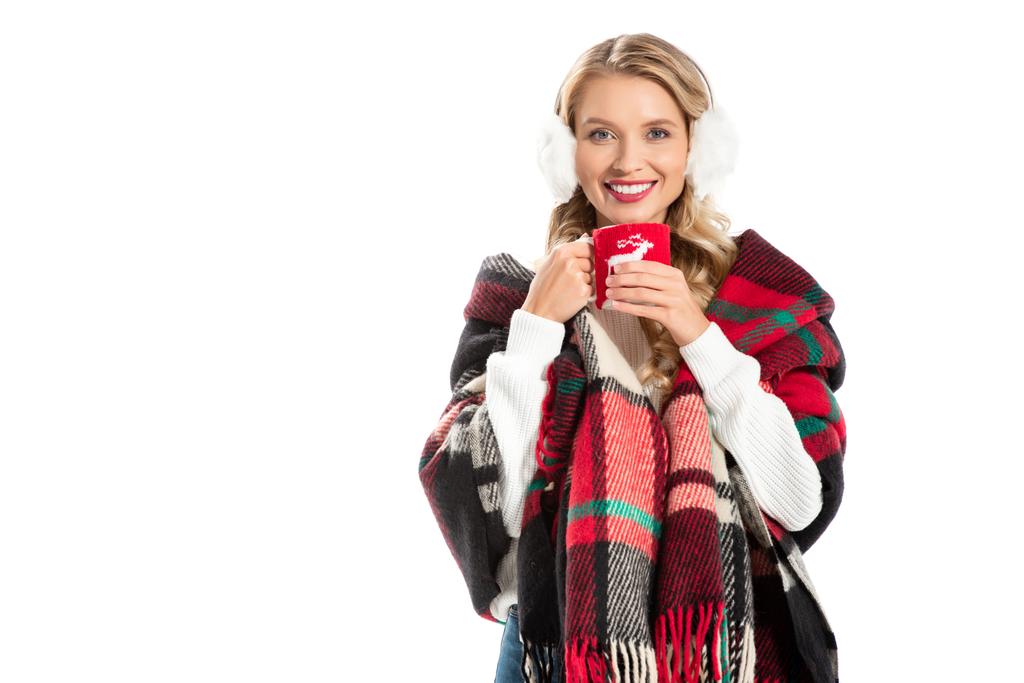 bella donna sorridente in coperta calda tenendo tazza di caffè isolato su bianco
 - Foto, immagini