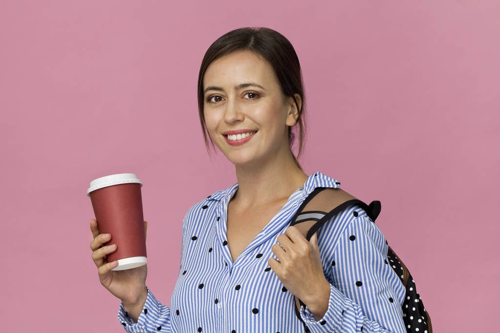 Mooie en charmante vrouwelijke student met rugzak en kopje koffie - Foto, afbeelding