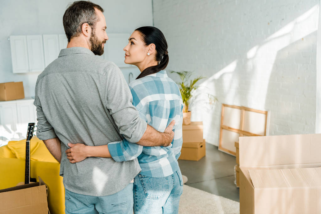 happy couple embracing while packing for new house, moving concept - Photo, Image