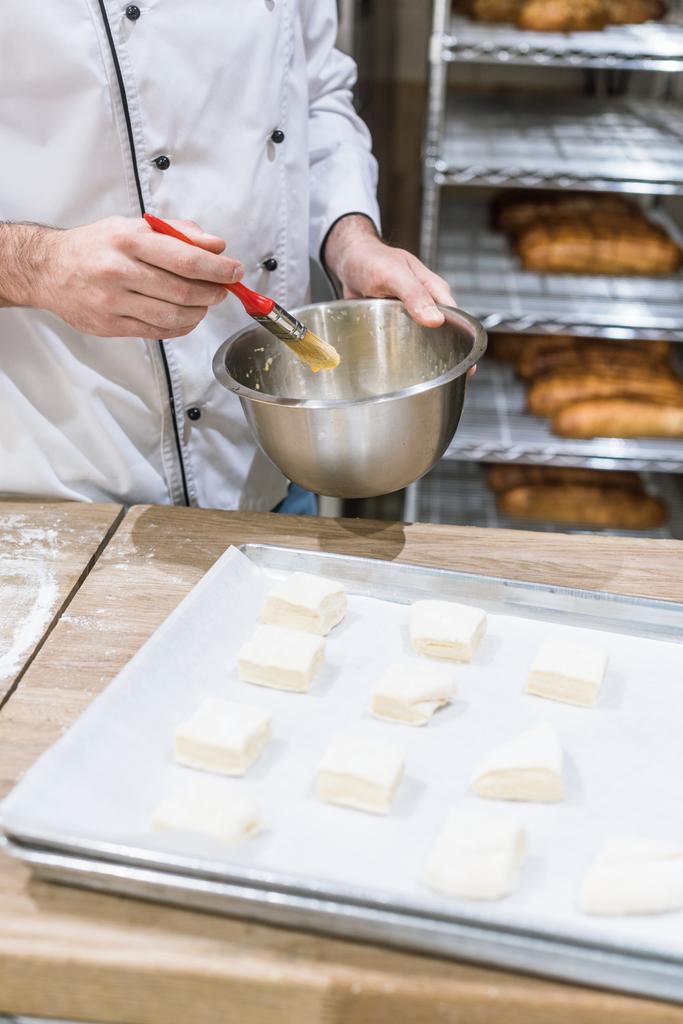 крупним планом кухарські руки мастила шматки тіста щіткою для вилову
 - Фото, зображення