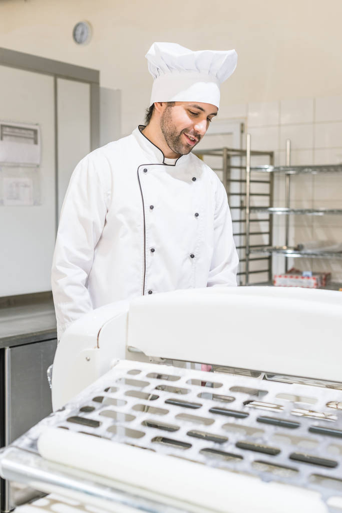 Guapo panadero en uniforme de chef en la cocina panadería
 - Foto, Imagen