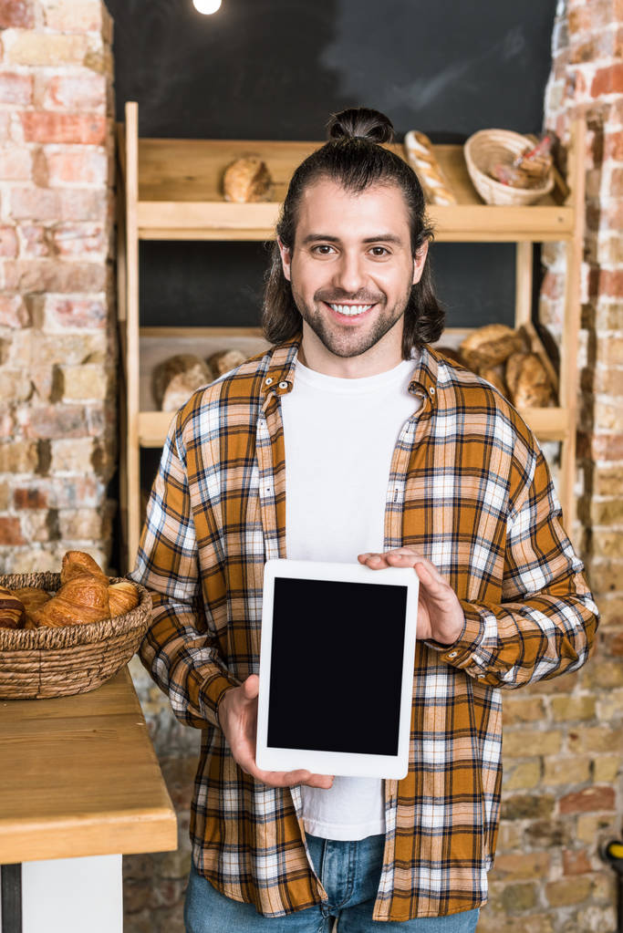 Гарний продавець тримає цифровий планшет у пекарні
  - Фото, зображення
