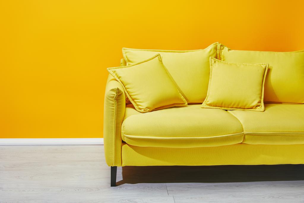 Canapé avec oreillers avec mur jaune à l'arrière-plan
 - Photo, image