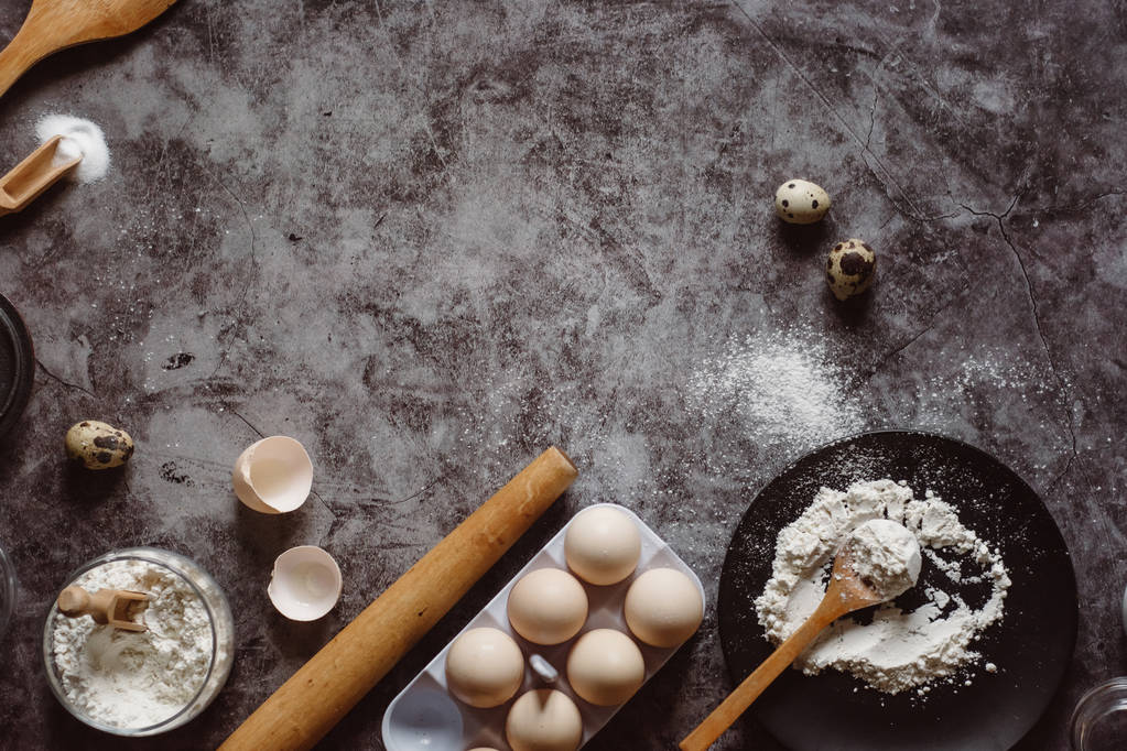 食材、ベーキングのための道具。小麦粉、料理、卵、バター、塩、灰色の背景に麺棒とスプーン。フラットが横たわっていた。テキスト スペース - 写真・画像