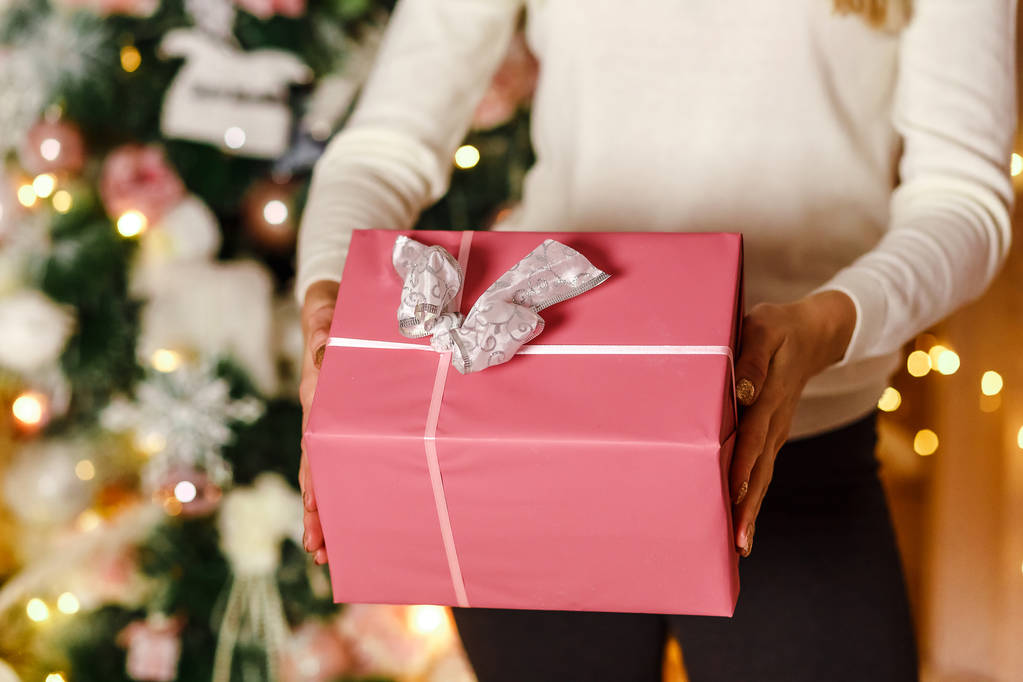 クリスマス プレゼント女性の手で美しいピンクのギフト ボックスします。 - 写真・画像