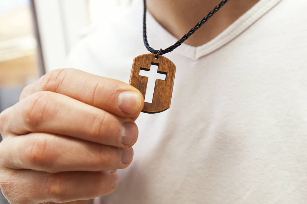 De houten kruis ketting op iemands hals - Foto, afbeelding