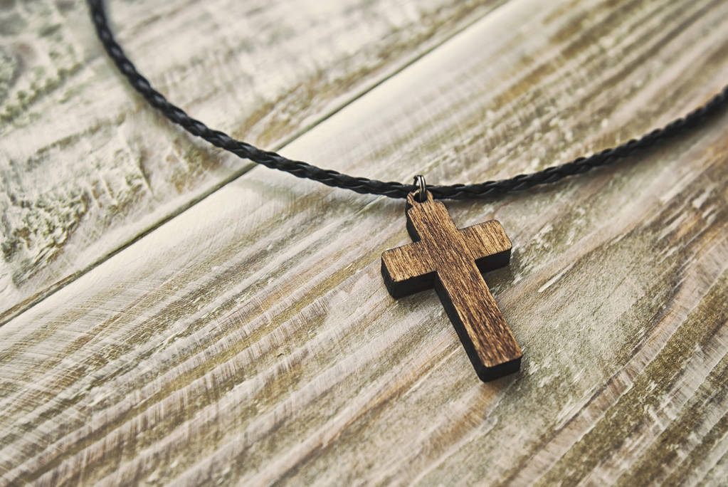 O pingente em forma de cruz na mesa de madeira
 - Foto, Imagem