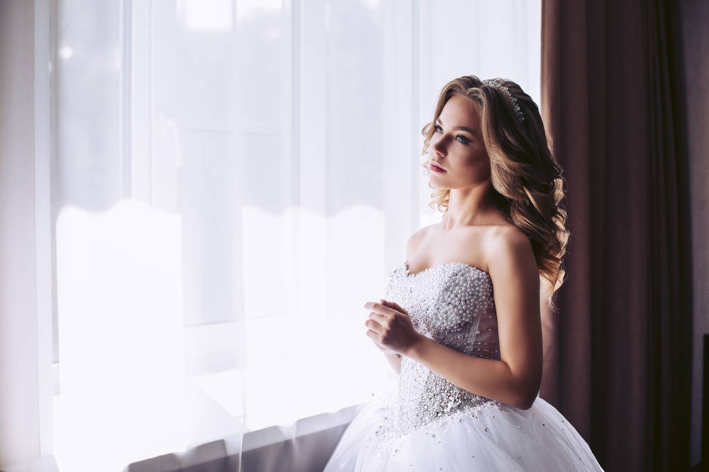 Okno vypadá mladá nevěsta v luxusní bílé šaty - Fotografie, Obrázek