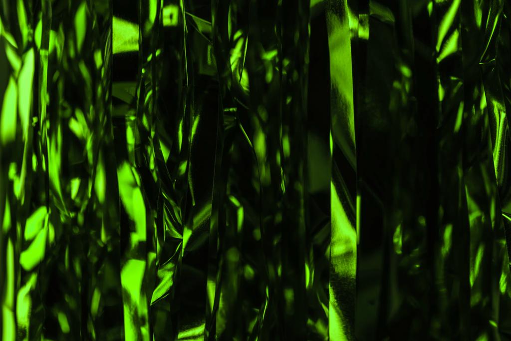 dunkelgrüne glänzende Luftschlangen als Neujahrshintergrund - Foto, Bild