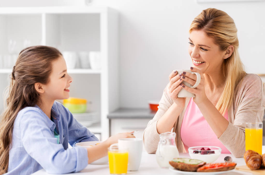 Mãe e filha felizes tomando café da manhã em casa
 - Foto, Imagem