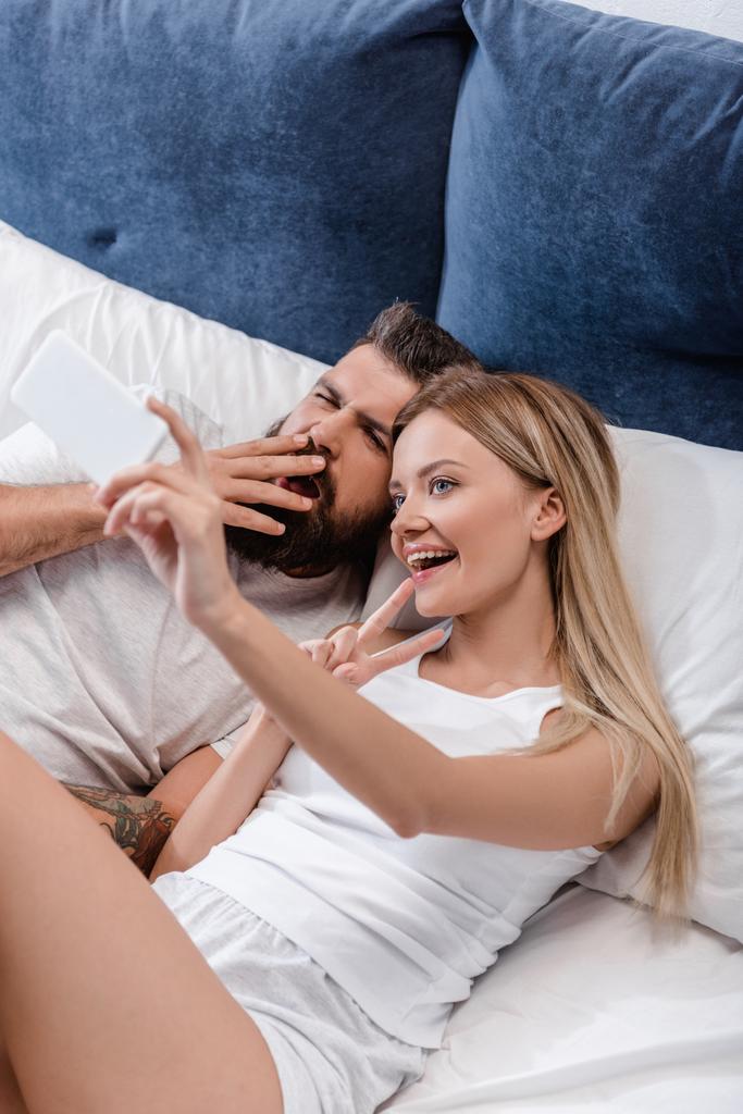 couple gai posant et prenant selfie au lit le matin
 - Photo, image