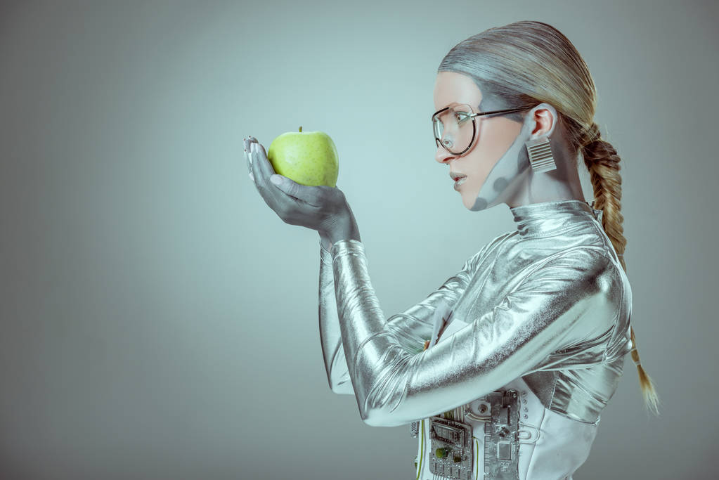 Seitenansicht einer Roboterin mit grünem Apfel isoliert auf grauem, zukünftigem Technologiekonzept - Foto, Bild