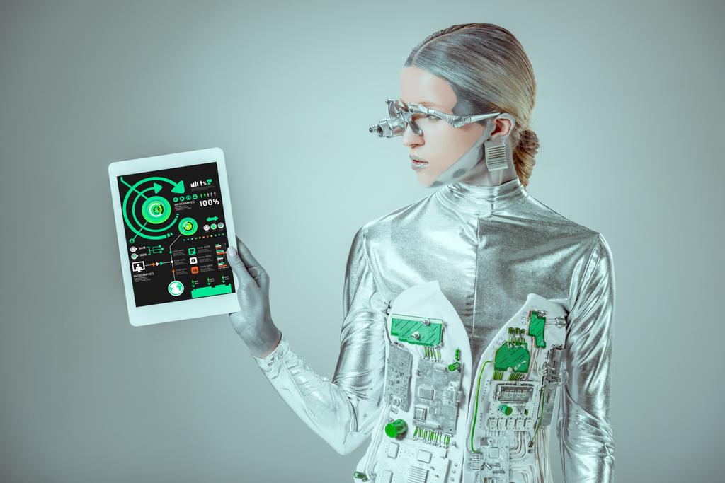 robot argenté regardant tablette avec appareil infographique isolé sur gris, concept technologique futur
 - Photo, image